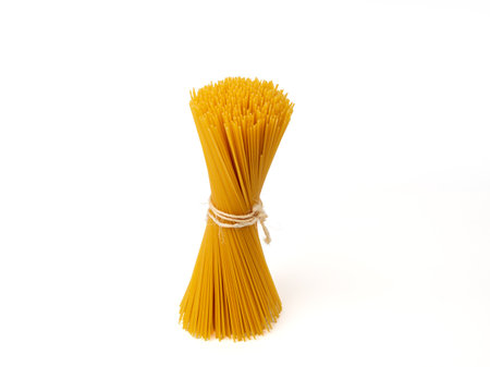 Spaghetti tied with rope on a white background. Raw spaghetti close-up.の写真素材