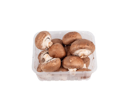 Champignon mushrooms in a plastic box on a white background. Champignon mushrooms close-up.の写真素材