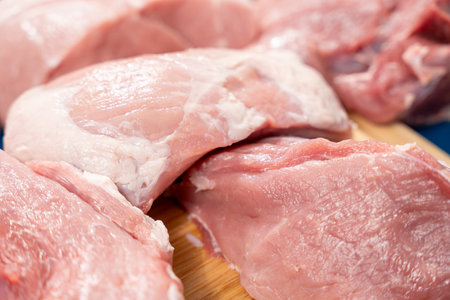 Pork meat cut into pieces lies on a cutting board. Pork meat close-up.の写真素材