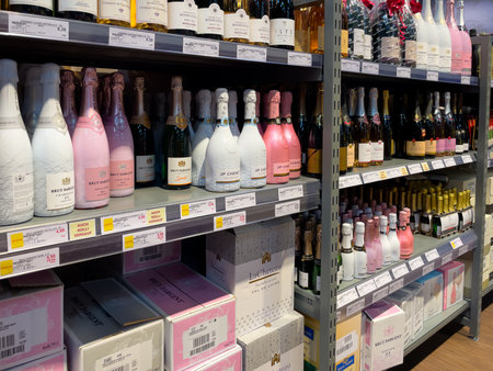 Germany Berlin May 11, 2024. A wine store with pink bottles of champagne on the shelves. The bottles are arranged in rows and are of different sizesのeditorial素材