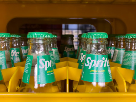 Germany Berlin May 11, 2024. A row of green bottles of Sprite are lined up in a yellow container. The bottles are all the same size and shape, and they all have the same label. Concept of uniformity and organizationのeditorial素材