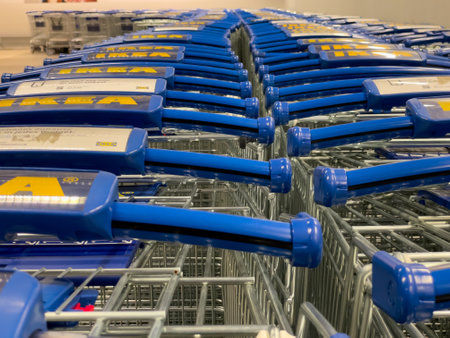 Germany Berlin May 27, 2024 A row of blue and yellow shopping carts are lined up in a store. Germany Berlin May 25, 2024のeditorial素材