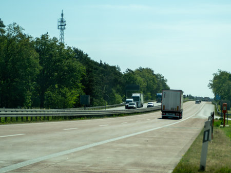 Germany May 17, 2024 A highway with a truck driving down it. The truck is carrying a trailer. There are several other cars on the roadのeditorial素材