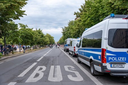 Germany Berlin June 14, 2024 A row of police vans are parked on a street. The street is empty and the sky is cloudyのeditorial素材