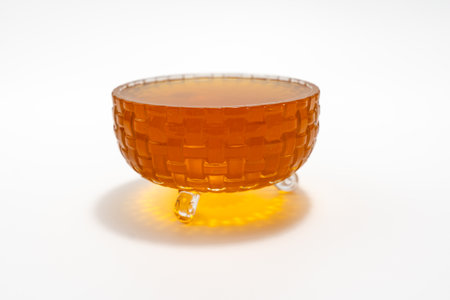 Small glass bowl with honey. It is located on a white surfaceの写真素材