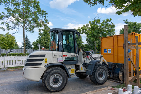 Germany Berlin August 5, 2024. A wheeled tractor stands on a construction site. Tractor for road works.のeditorial素材