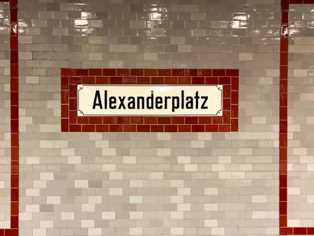 A white and red brick wall with a sign that says Alexanderplatz.