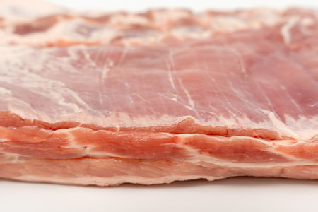 A piece of meat with a white background. The meat is cut in half and has a pinkish color Pork meat isolated on a white background.の写真素材