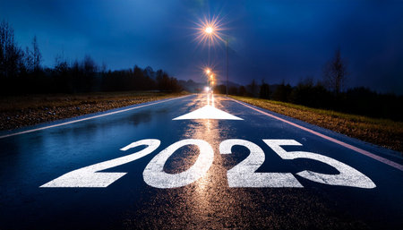 A road with a white line and the number 2025 written on it. The road is wet and the sky is darkの素材