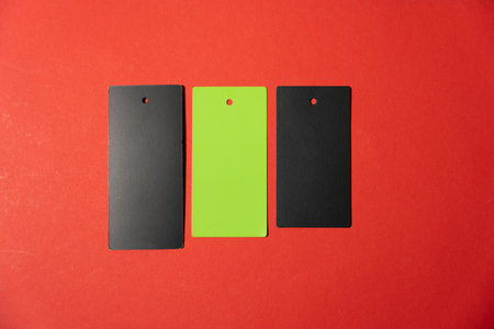 Three marks are on a red background. The marks are black and one is green. Tags are arranged in a row.の写真素材