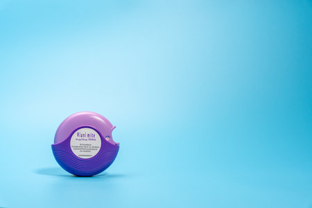 Germany Berlin November 21, 2024. Purple asthma inhaler on blue background.