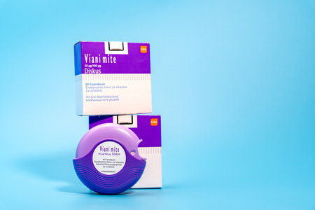 Germany Berlin November 21, 2024. Purple asthma inhaler and two packages on blue background.のeditorial素材