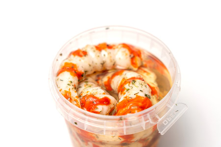 Container with Surimi in the form of shrimp sauce and white background. The food is in the container and is a type of seafood.の写真素材