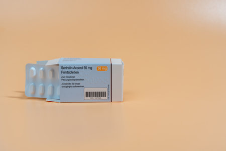 Germany Berlin November 29, 2024. A box of tablets with a white label reading Sertralin Accort. Packaging of pills on an orange background.のeditorial素材