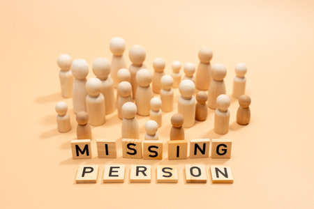 A group of wooden people are arranged in a circle with the word missing person. The concept of...