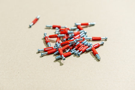 Metal screws for furniture assembly lie on a cardboard surface. Furniture screws close-up.の写真素材