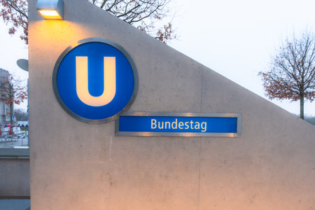 A blue and white sign with the letter U Bundestag on it. The sign is on a building. The sign is in a foreign languageの写真素材