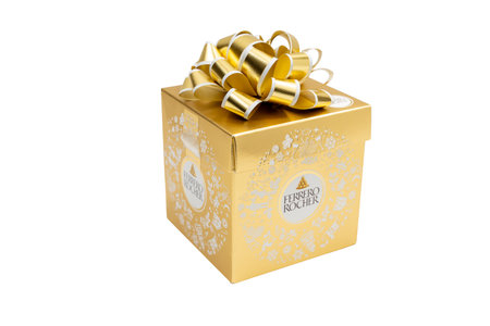 Gold box of chocolates with a ribbon at the top with the inscription Ferrero Rocher. Gift box of chocolates on white background.のeditorial素材