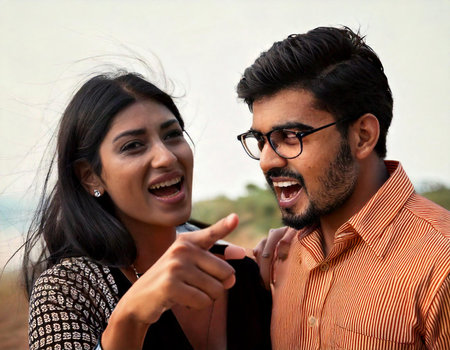 A man and a woman are smiling at the camera. The man is pointing at something. The woman is wearing a black dressの素材