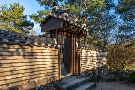 A stone wall with a wooden gate. The gate is openの写真素材