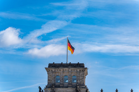 The German flag flutters on the Reichstag building. The flag flutters against the sky.の写真素材