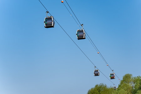 A cable car system with four cars on it. The sky is blue and clearの写真素材