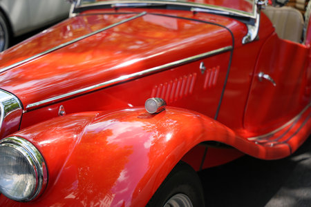 Red vintage roadster with rounded fender light. Bright red vintage roadster with a small round...