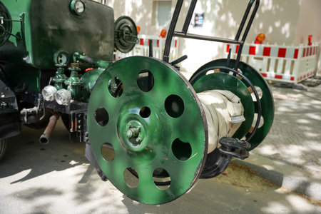 A large green hose reel. A hose reel with a coiled fire hose on a historic fire truck, displayed...