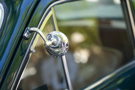 Classic round vintage car side mirror in shiny chrome, perfectly reflective. Part of a vintage classic car.の写真素材