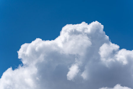 Large White Cloud Against a Blue Sky. A huge, fluffy cumulus cloud stands out brilliantly against...