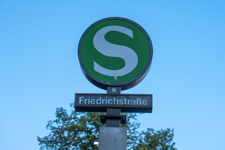 S-Bahn sign at Berlin's Friedrichstrase station with a clear blue sky in the background. Iconic green circle with a white S symbolizes urban rail transit.の写真素材