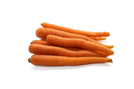 Fresh whole carrots stacked in a bundle. The carrots are isolated on a white background.の写真素材