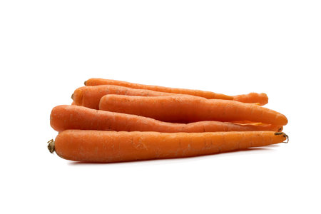 Fresh carrots piled together. These vegetables are isolated on a white background.の写真素材