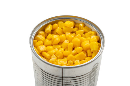 Close-up of an open tin can filled with golden corn kernels. The product is isolated on a white background.の写真素材
