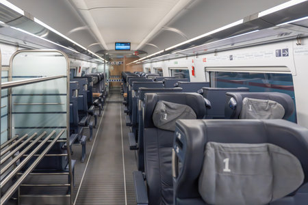 First class train interior wide view. Spacious first-class train carriage with leather seats and...