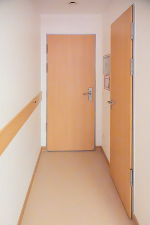 Hallway with doors. A simple hallway with wooden doors and handrails creates a clean, functional...