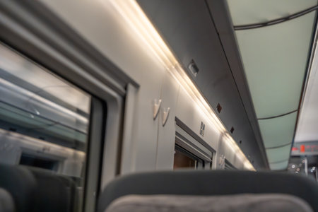 Train ceiling and luggage area. Illuminated train ceiling with overhead compartments and windows. Clean design and warm lighting create a peaceful travel mood.の写真素材