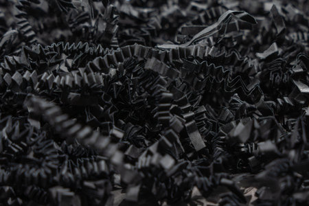 Black Crinkle Paper Close-up. Detailed macro view of black crinkle paper filling material. Ideal for...