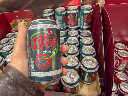 Germany Berlin February 7, 2026. Hand holding a Dr Pepper Cherry can in a retail display box. Limited edition soda presentation highlighting flavor variety, branding, and consumer choice.のeditorial素材