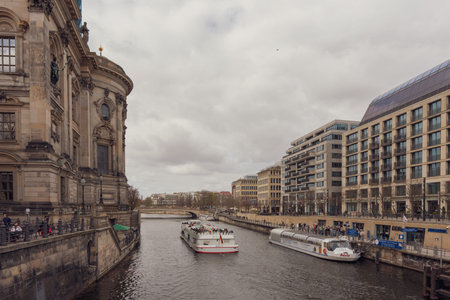 Germany Berlin March 27, 2026. Grand canal flows beneath historic stone architecture. Tour boats...