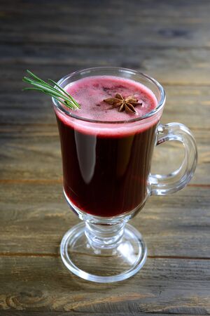 hot warming drink with spices and cranberry juice, decorated with a sprig of rosemary and star anise.の写真素材