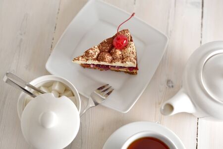 cake, tea Cup and sugar bowl on a wooden countertopの写真素材