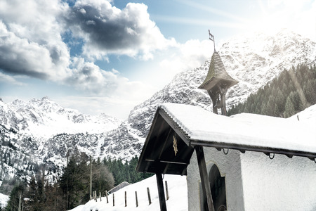 A little chapel striped by sunlight on the way to the mountains in Oberstdorf Germany.の写真素材