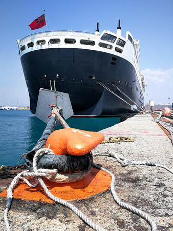 Cruise ship laying at the a pier in the mediterranean sea held tight with ropes at a bollard.の写真素材