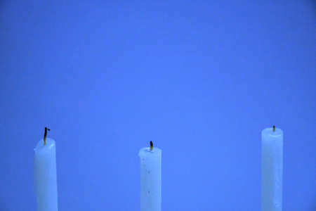 White Candles Burning in the Dark with lights glow, the burning candle's flame in the dark background, a symbol of the Christian faith, Candles Burning in the Dark with lights glow.の写真素材