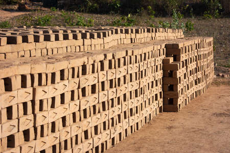Hand made bricks from wet clay and mud are kept for drying before the burning process. Traditional production of clay bricks in India.の写真素材
