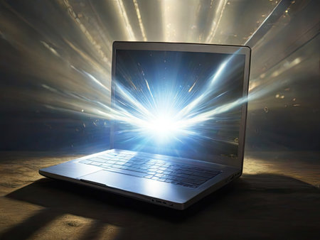Laptop with rays of light coming out of the screen in dark roomの素材