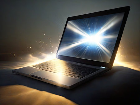 Laptop in the dark with sun rays coming out of the screenの素材
