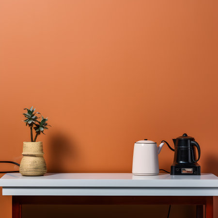 White coffee pot on table near orange wall. Minimal style.の素材
