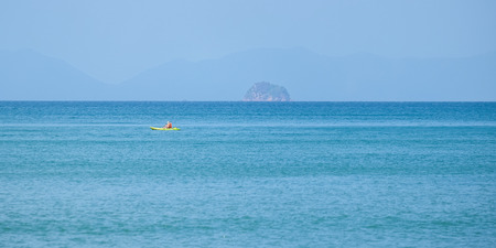 A man paddling on a red and green canoeの写真素材